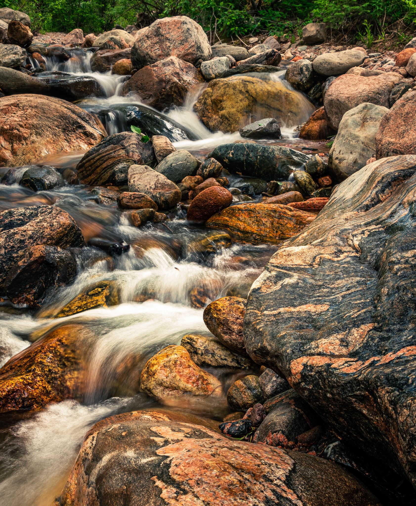 Moving water among colorful creek rocks